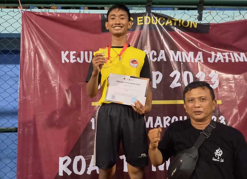 DISEGANI LAWAN: Andre menerima penghargaan juara kompetisi MMA 2023 di Surabaya. (Andre Wiranata untuk Radar Tuban)