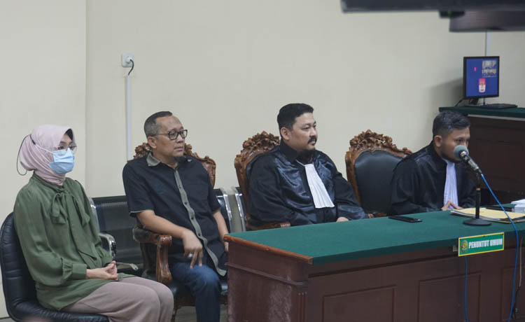MENCARI CELA: Puput Tantriana Sari (kiri) dan Hasan Aminuddin (dua kiri) berdiskusi dengan pengacaranya dalam sidang PK di Pengadilan Tipikor Surabaya, Selasa (4/7). (Foto: Lugas Wicaksono/Jawa Pos)