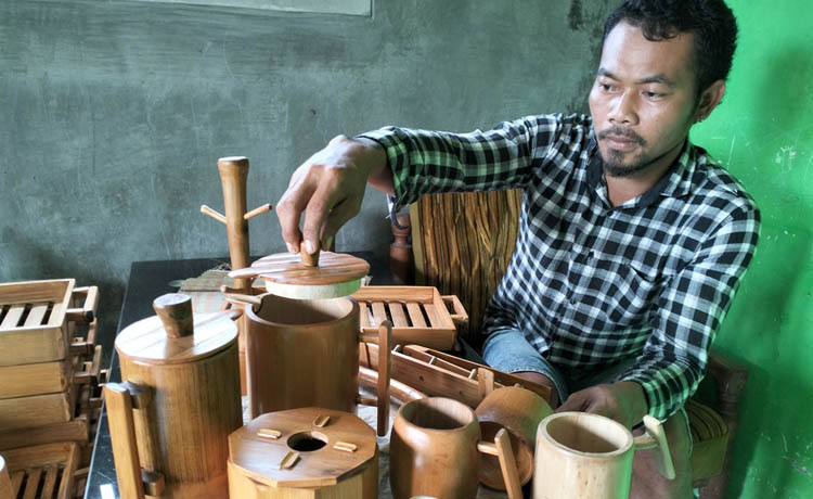 SIAP JUAL: Bandri Handoko dengan aneka kerajinan karyanya dari bambu petung yang sudah jadi. (Foto: Rizal F Syatori/Jawa Pos Radar Bromo)