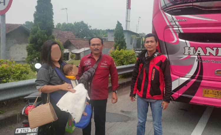 AKHIRNYA PULANG: LA menggendong anaknya diantar petugas kepolisian untuk pulang ke Tangerang, (Foto: Rizal F Syatori/Jawa Pos Radar Bromo)