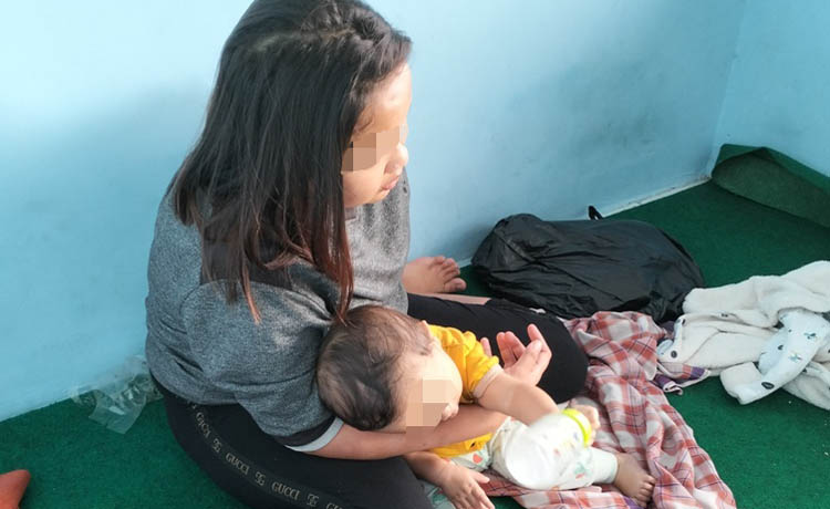 KASIHAN: LA bersama putranya yang masih balita, menaiki bus menuju Tangerang dengan diantar petugas kepolisian. (Foto: Rizal F Syatori/Jawa Pos Radar Bromo)