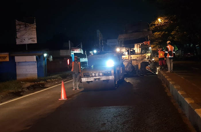 DIGARAP MALAM: Sejumlah pekerja sibuk mengaspal hotmix ruas jalan nasional Surabaya-Malang di Desa Karangjati, Pandaan, Minggu malam (2/7).