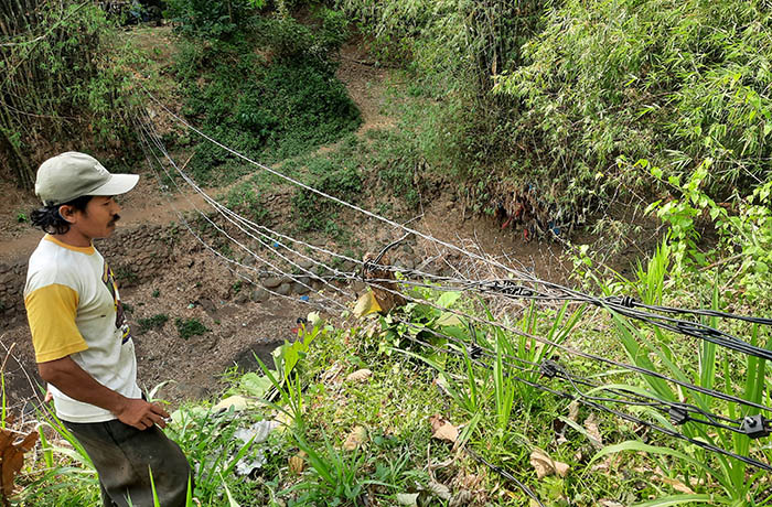 MEMBAHAYAKAN: Kabel listrik PLN di Dusun Dawuhan, Desa Karanganyar, Kecamatan Bantaran, Kabupaten Probolinggo, hampir menyentuh tanah. Sudah lama kondisi ini dikeluhkan warga.