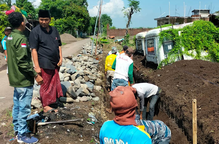 LIHAT LANGSUNG: Kepala Desa Lemahkembar Hariyanto bersama pendamping desa memantau pembangunan drainase. (Pemerintah Desa Lemahkembar for Jawa Pos Radar Bromo)