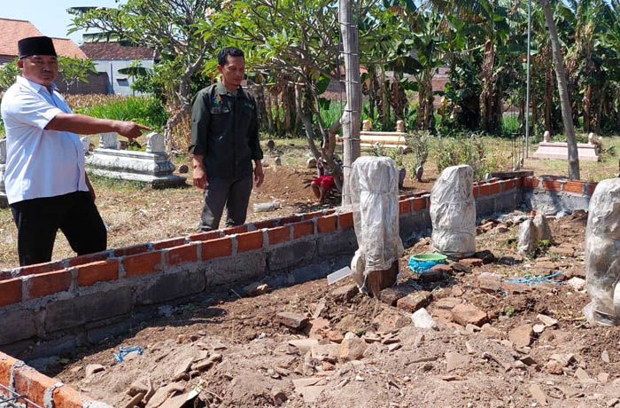 SESEPUH DESA: Kasi Pembangunan Desa Lemahkembar menunjukkan kegiatan pembangunan pagar makam pembabat alas Desa Lemahkembar, Bujuk Kuningan. (Arif Mashudi/Jawa Pos Radar Bromo)