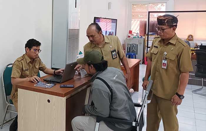 CEK: Kepala Dispendukcapil Munaris (memakai udeng) mengontrol pelayanan yang dilakukan petugasnya. (Foto: Agus Faiz Musleh/Jawa Pos Radar Bromo)