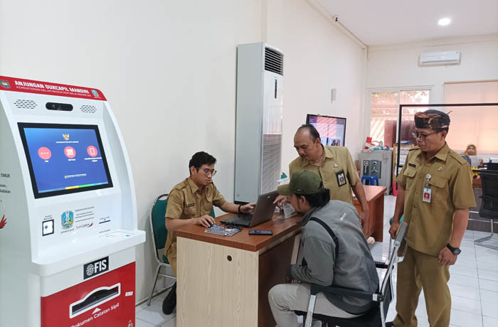 CEK: Kepala Dispendukcapil Munaris (memakai udeng) mengontrol pelayanan yang dilakukan petugasnya. (Foto: Agus Faiz Musleh/Jawa Pos Radar Bromo)