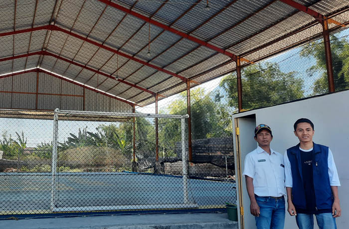 LEBIH MURAH: Perangkat Desa Mentor Hari Cahyono (kiri) dan ketua karang taruna Nanang Hendra Jaya (kanan) di depan lapangan futsal. &nbsp;(Foto: Fahrizal Firmani/Jawa Pos Radar Bromo)