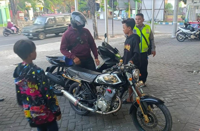 TERJARING: Anggota Satlantas Polres Probolinggo Kota ketika menghentikan pengendara motor yang tak memakai helm. (Humas Polres Probolinggo for Jawa Pos Radar Bromo)