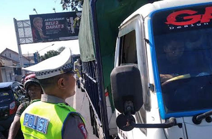 STOP: Salah seorang anggota menyetop truk masuk kota. (Humas Polres Probolinggo for Jawa Pos Radar Bromo)