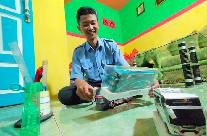 UNIK: Rifky Ardhani Arishandy, 18, perajin miniatur paper bus saat menunjukkan kreasinya. Pesanan miniatur bus dari kertas ini terus berdatangan.