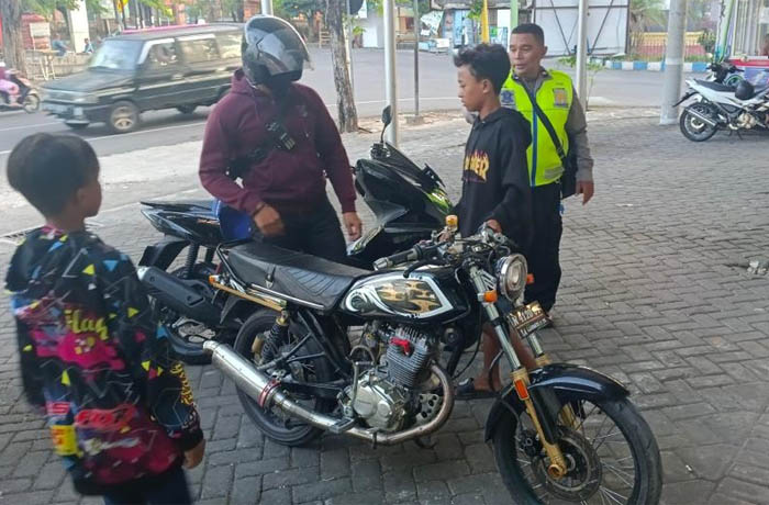 DITINDAK: Salah satu pengendara moor yang kedapatan memakai knalpot brong, dikenai tilang oleh personel Satlantas Polres Probolinggo Kota. (Foto: Polres Pasuruan for Jawa Pos Radar Bromo)