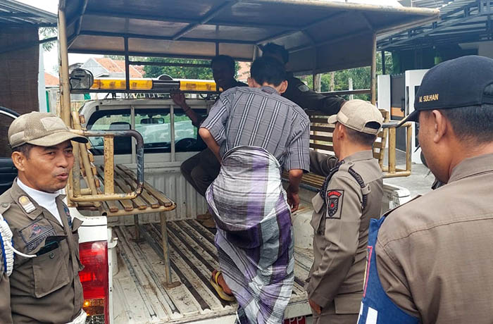 DIAMANKAN: Anggota Satpol PP mengamankan Samsul Arifin, yang berulah di rumah warga di Kelurahan Kebonsari Wetan, Senin (24/7).
