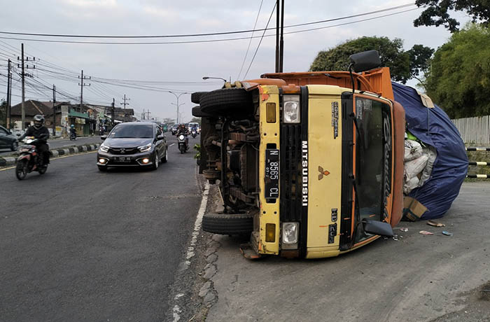 KECELAKAAN TUNGGAL: Kondisi truk muat avalan yang terguling di Purwosari usai ban belakangnya terlepas, Senin (24/7).