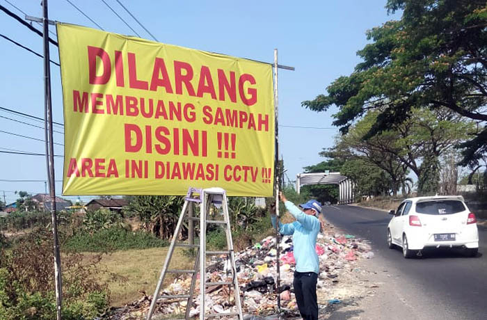 BENTUK PROTES: Warga memasang banner berisi larangan buang sampah di tepi jalan nasional lantaran kawasan tepi jalan nasional jadi tempat langganan buang sampah sembarangan.