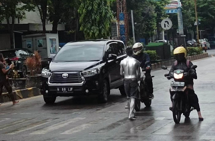 KERAP TERLIHAT: Manusia silver yang mangkal di traffic light Pasar Sore, Kraksaan. (Agus Faiz Musleh/Radar Bromo)