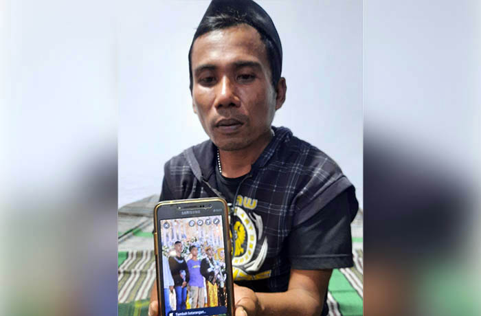 MINTA DIHUKUM BERAT: Slamet, paman korban Samsul Arifin memperlihatkan foto korban. Dia minta pelaku yang menganiaya korban dihukum berat.