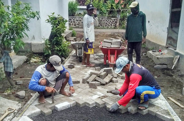 MAKIN NYAMAN: Sejumlah pekerja mempaving jalan di RT 5/RW 2, Dusun Pasar, Desa Banyunyar Lor. Ruas jalan ini merupakan akses menuju permukiman padat penduduk dan musala.