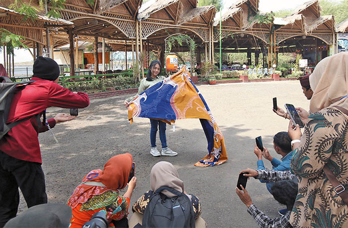 PRAKTIK OUTDOOR: Peserta Diklat Jurnalistik Foto-Video praktik langsung cara mengambil foto-video produk kain batik dengan model di Pantai Bohay Paiton.
