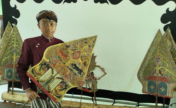 BAKAT DARI KELUARGA: Galih Rakasiwi memegang salah satu wayang usai latihan di sekolahannya. (Foto: Rizal F Syatori/Jawa Pos Radar Bromo)