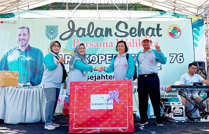 DAPAT MESIN CUCI: Dini, salah satu insan koperasi yang beruntung, tak menyangka mendapatkan door prize utama mesin cuci. (Foto: Istimewa)