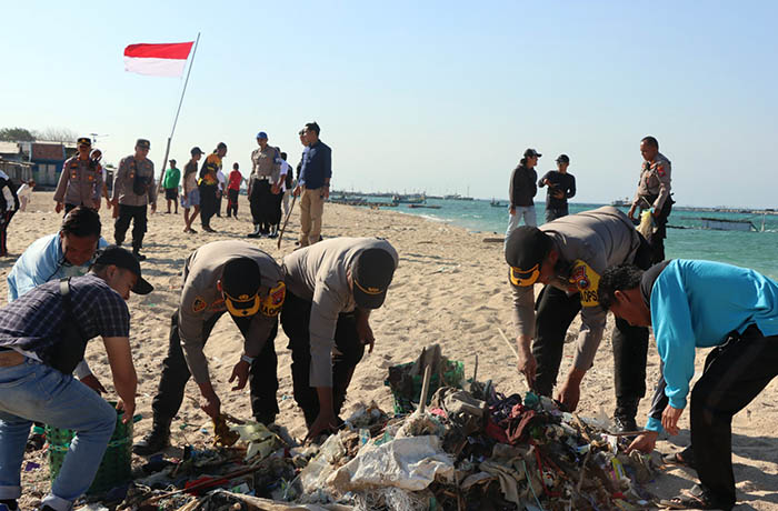 BERSIH-BERSIH: Sejumlah anggota Polres Probolinggo Kota bersama pihak terkait bersih-bersih sampah di Pulau Gili Ketapang, Kecamatan Sumberasih, Rabu (16/8).