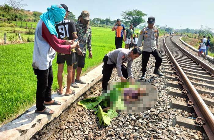 NAHAS: Petugas saat hendak mengevakuasi jenazah nenek Asiya yang tewas dihantam KA, Sabtu (19/8)