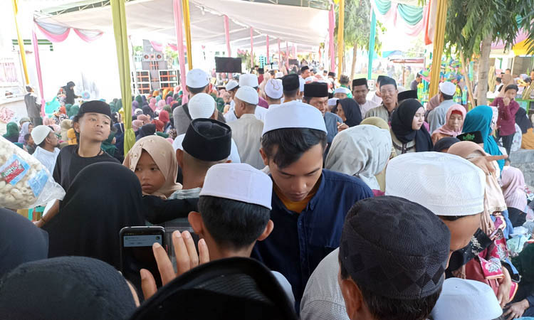RAMAI: Jamaah berdesak-desakan menuju lokasi haul. Di kanan-kiri jalan juga berdiri ratusan bedak pedagang. Jamaludin/Radar Bromo