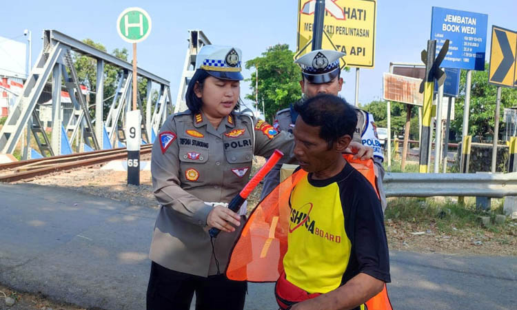 UNTUK KESELAMATAN: Personel Satlantas Polres Pasuruan Kota membagikan rompi dan senter kedip pada salah satu relawan di Bokwedi, Kelurahan Blandongan, Senin (28/8). Satlantas Polres Pasuruan Kota for