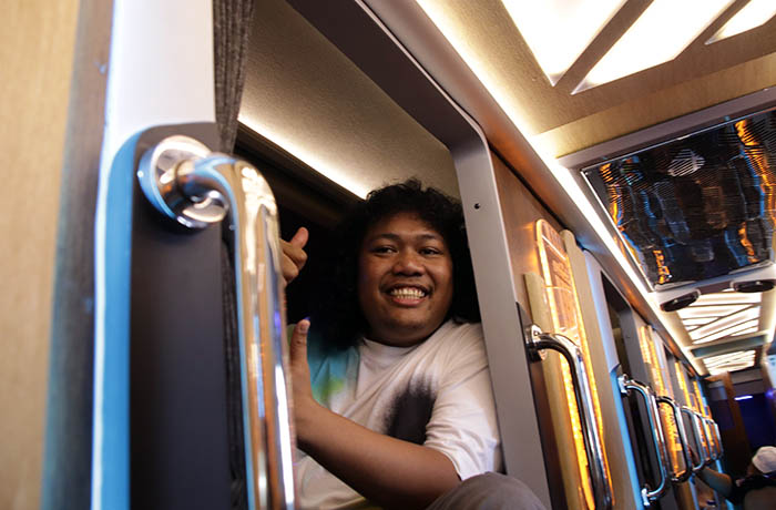 COBA LANGSUNG: Marshel Widianto, artis Indonesia menikmati langsung duduk dan tidur di Sleeper Bus yang disajikan Juragan99 Trans untuk AKAP Malang-Denpasar.