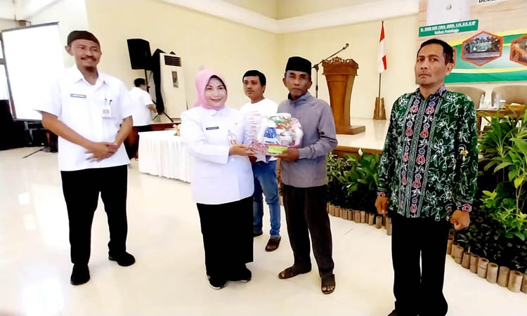 SIMBOLIS: Sekda Ninik Ira Wibawati didampingi Kepala DKPPP Aries Santoso menyerahkan simbolis bahan praktik SL-PTT kepada perwakilan kelompok tani. Evelyn Ridhayanti/Radar Bromo