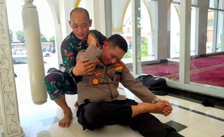TIDAK KOMERSIL: Koptu Rahmad Hadi Susanto saat memijat kretek seorang perwira di Polres Pasuruan.