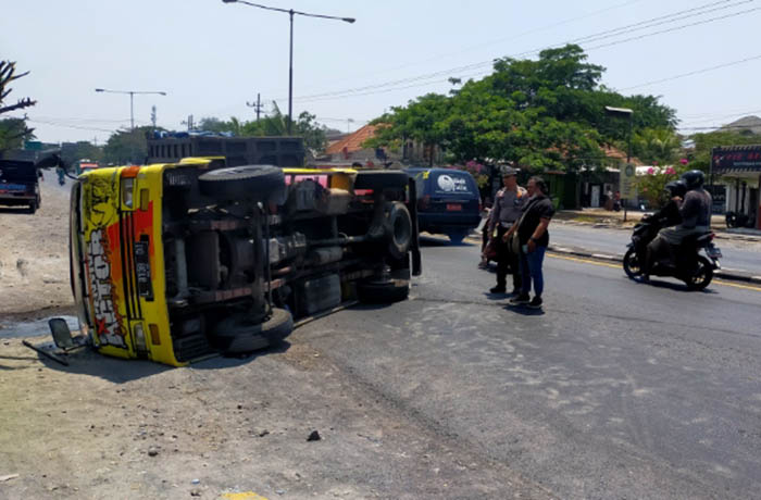 HILANG KENDALI: Kondisi truk tangki muat tinja usai terguling di ruas jalan raya Raci, Bangil, kemarin siang.