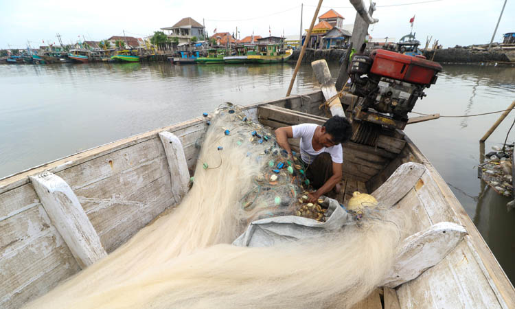PARKIR: Nelayan di Pelabuhan Pasuruan membenahi jalanya. Belum semua kapal nelayan di Kota Pasuruan kantongi dikumen untuk melaut.
