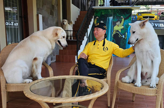 SANTAI: Tony Liono, bersama anjing herder peliharaannya. Sejumlah anjing di rumahnya di Kelurahan Ledug, Kecamatan Prigen, Kabupaten Pasuruan, dirawat sejak kecil.