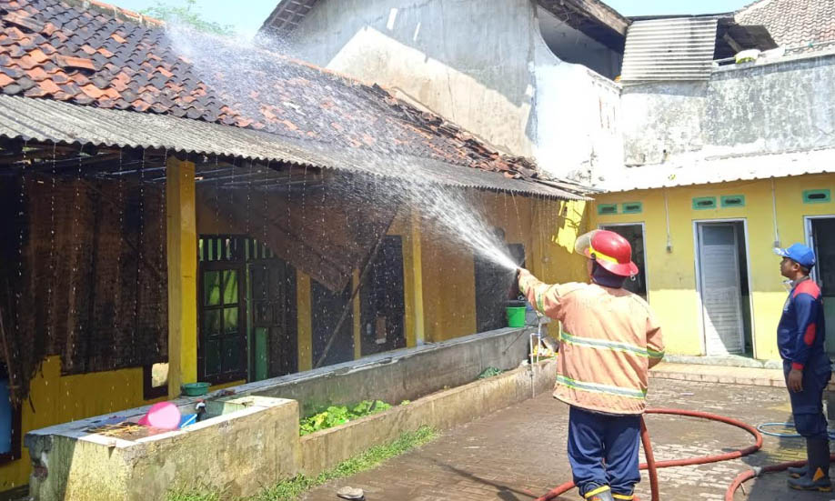 SEMPROT: Petugas melakukan pendinginan usai berhasil memadamkan api di Yayasan Miftahul Ulum di Bendungan, Kraton, Kamis (21/9) lalu.