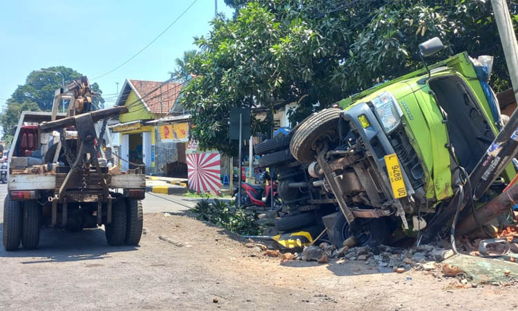 GULING: Truk bermuatan kaca yang dikemudikan Ahmad Mujahidin, terguling di Jalan Raya Dringu, Kabupaten Probolinggo, Senin (25/9).