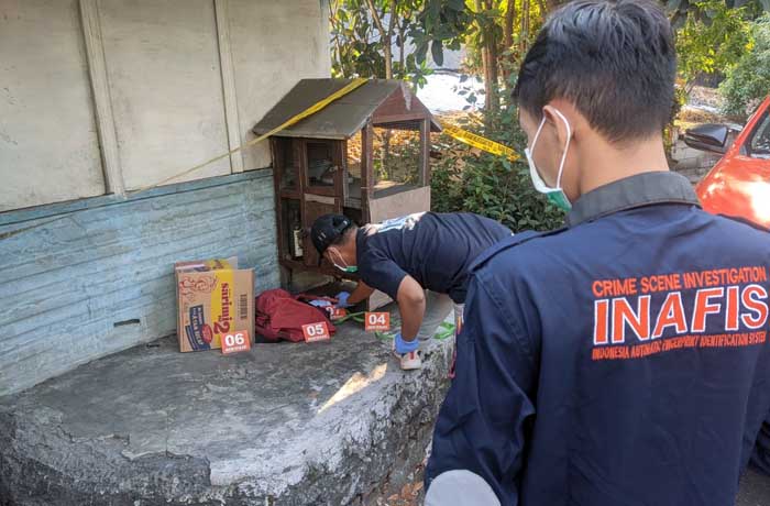 POLICE LINE: Petugas saat melakukan olah TKP penemuan mayat bayi dalam kardus di teras warung kopi Tretes. (Rizal Syatori/ Radar Bromo)