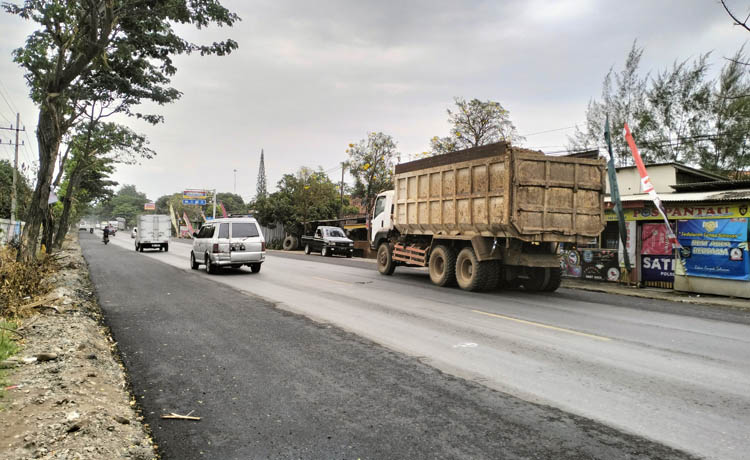 DILEBARKAN: Beberapa kendaraan melintas di Ruas Jalan Desa Binor, Kecamatan Paiton yang baru selesai dilebarkan.
