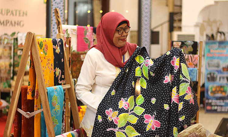 PELOPOR BATIK: Nur Hayati, 53, menunjukkan batik karyanya di stan pameran UMKM di hall P3GI Pasuruan.