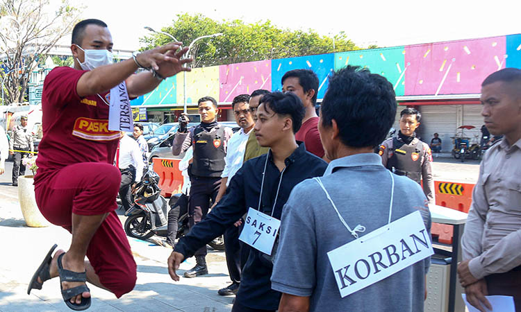 REKONSTRUKSI: Terdakwa Ahmad Asrafi, 20, saat memeragakan caranya menendang korban Afrizal Ramadani dengan dengkulnya.