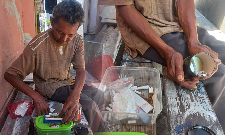 LEBIH MURAH: Abdul Rohim, 54, warga Kelurahan/Kecamatan Mayangan, Kota Probolinggo, saat melinting rokok menggunakan alat linting di rumahnya.