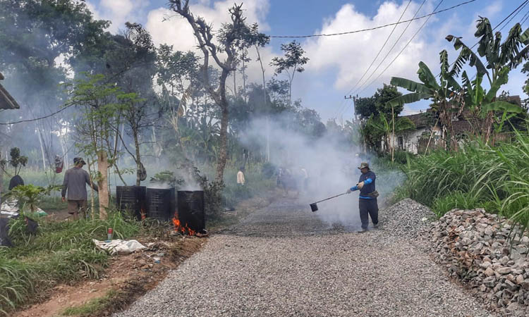 DIBANGUN: Pekerja sedang melakukan pengaspalan jalan sepanjang 363 meter di RT. 7/RW 2, Dusun Tengah.