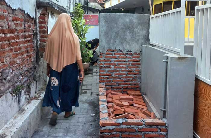 DITEMBOK: Sisilia menunjukkan tembok setinggi 1,5 meter dibangun Jumina di depan rumahnya di jalan Ikan Kerapu RT 05 RW 09, Kelurahan Mangunharjo, Kecamatan Mayangan. (Inneke Agustin/ Radar Bromo)