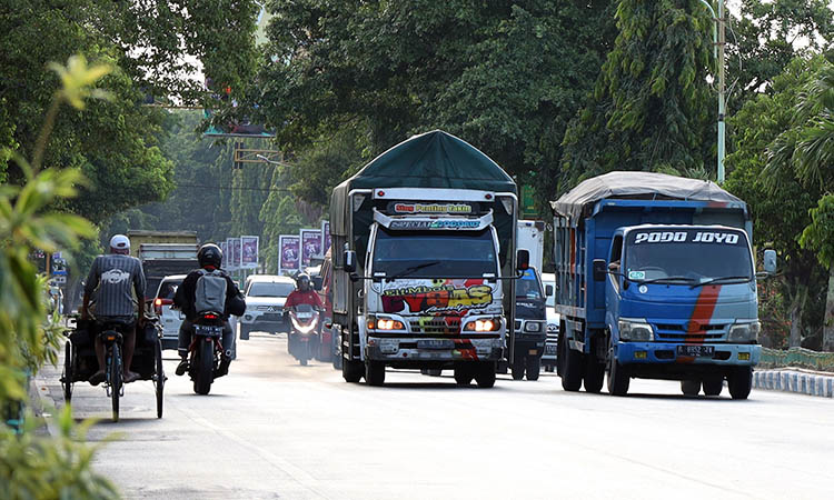 MELANGGAR: Sejumlah truk melintas di Jalan Soekarno-Hatta Kota Probolinggo. Serta, salah satu truk melintas di Jalan Gatot Subroto. Dua jalur perkotaan.