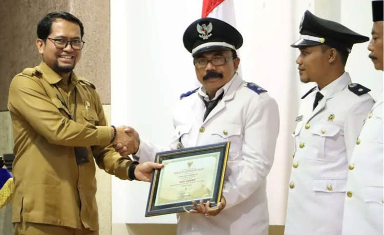 APRESIASI: Kepala Dinas PMD Kabupaten Probolinggo Fathur Rozi menyerahkan piagam penghargaan kepada Kepala Desa Kedungrejo Endi Supriadi setelah desanya berstatus Desa Mandiri.