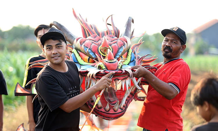 SIAP DITERBANGKAN: Novem (kiri) bersama Rudi Hariyanto, siap menerbangkan layangan naga di Kelurahan Sumbertaman, Kota Probolinggo.