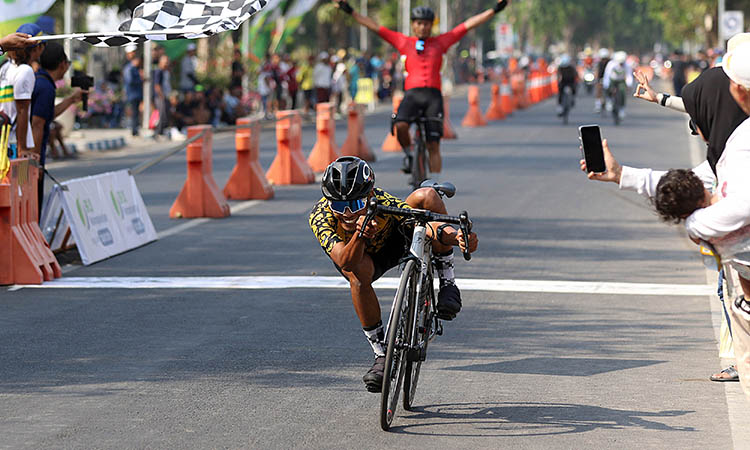 SELEBRASI: Gaya Jamal Andriyanto, pembalap asal Kota Pasuruan saat finish di nomor Criterium Men Master Lokal.