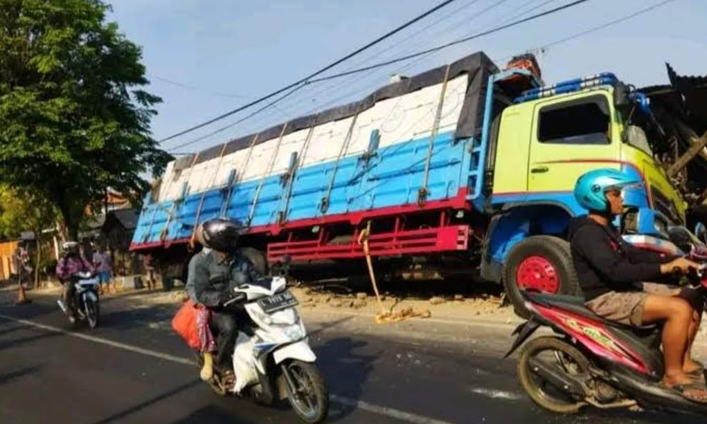 OLENG: Truk tronton menyasak pagar dua rumah milik warga Kelurahan Kandangsapi, Kecamatan Panggungrejo, Kota Pasuruan, Sabtu (21/10).