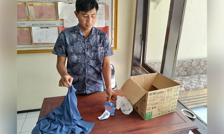 BARANG BUKTI: Petugas menunjukkan sejumlah barang bukti yang diamankan dari lokasi penemuan mayat bayi perempuan di tepi jalan provinsi.